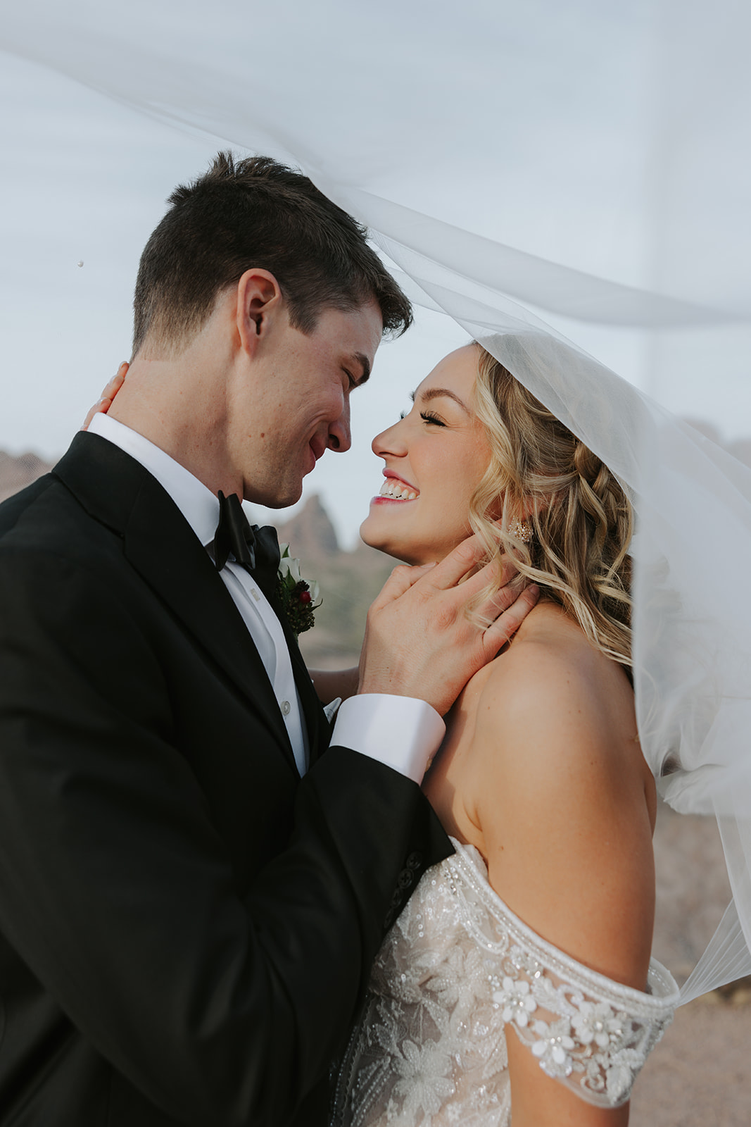 Catholic bride and groom on their wedding day under the veil at Papago park in Tempe, Arizona
