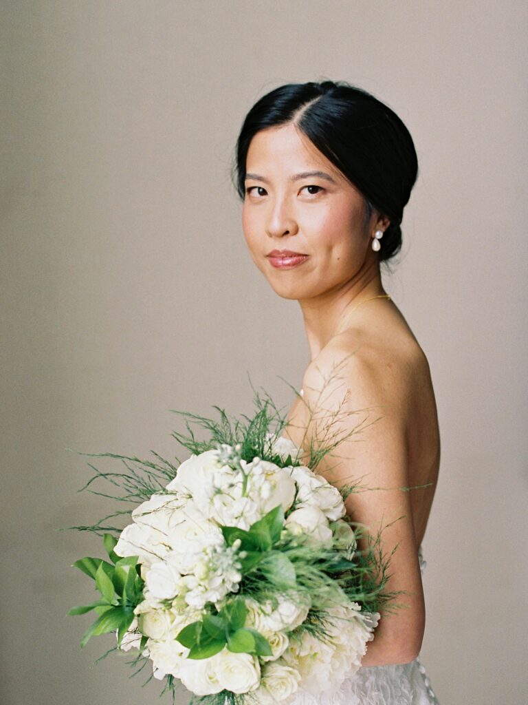 a catholic brides stops for a quick portrait on her wedding day in chicago illinois holding her bouquet of flowers 