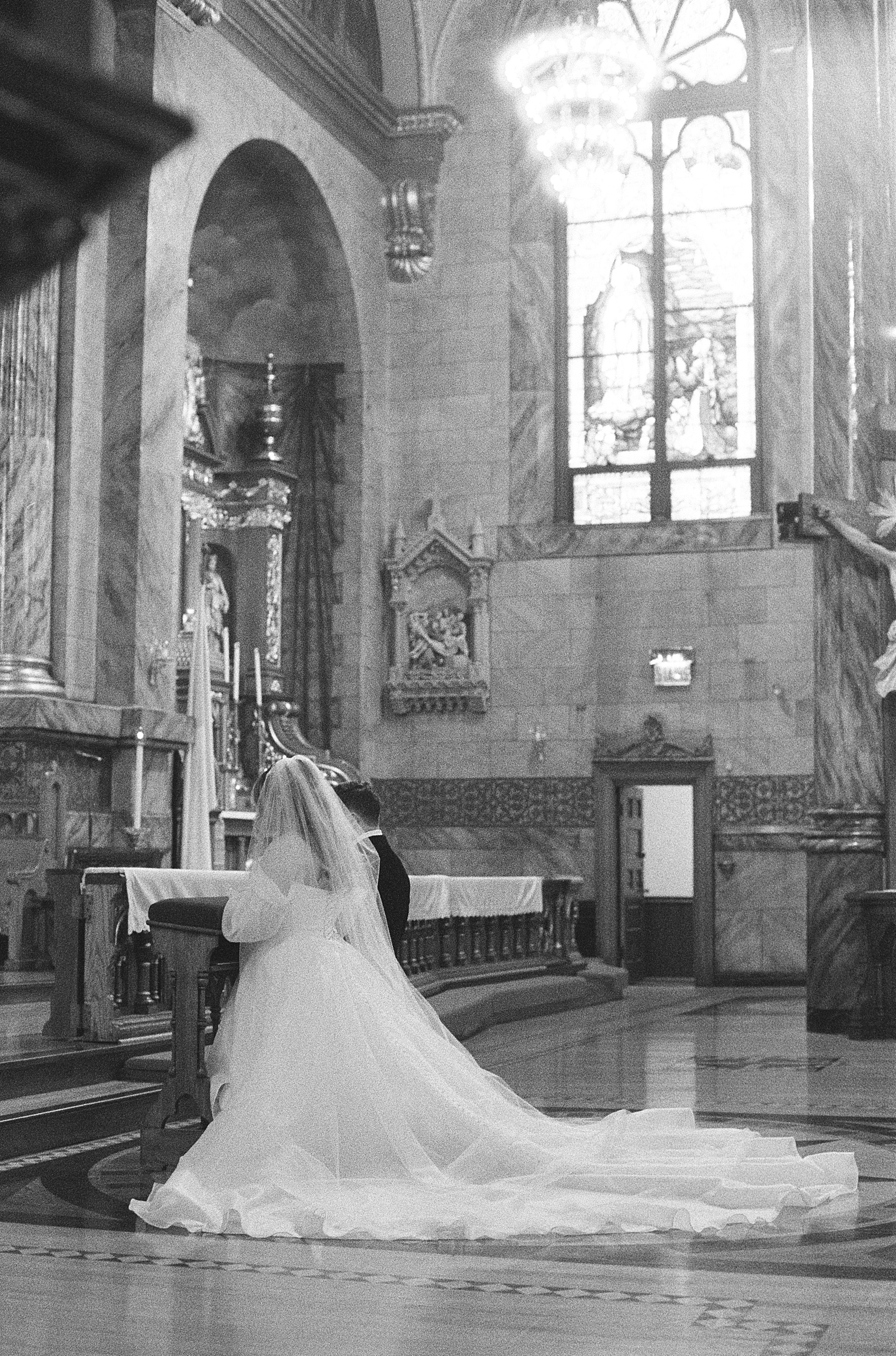 a catholic couple kneels before the altar at their catholic wedding mass at saint john cantius church in chicago illinois