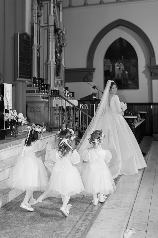 A black and white photo of a bride and flower girls at St. John the Evangelist in Indianapolis 
