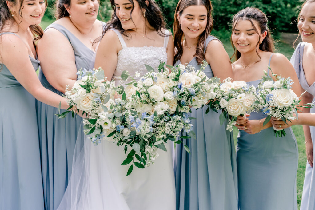 A bride and bridesmaids with blue and white flowers